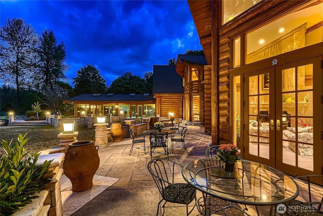 patio at night featuring french doors and outdoor dining area