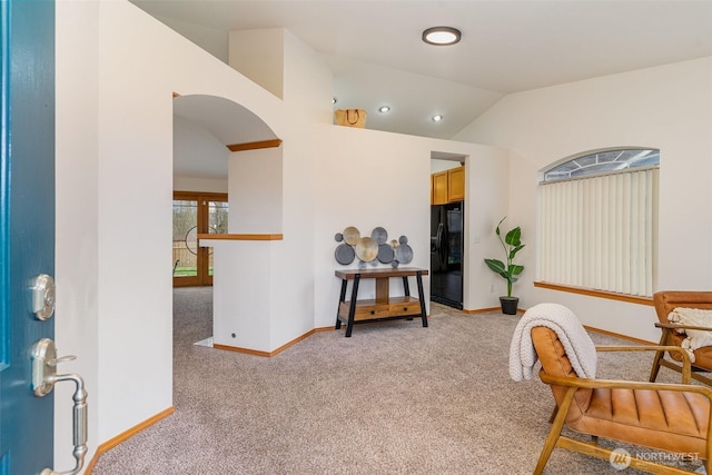 sitting room with baseboards, light carpet, and vaulted ceiling