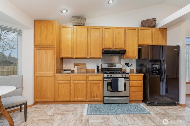 kitchen with under cabinet range hood, gas stove, recessed lighting, black refrigerator with ice dispenser, and vaulted ceiling