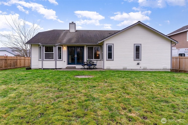 rear view of property with a fenced backyard, a lawn, and a chimney