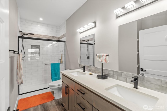 bathroom featuring a shower stall, wood finished floors, and a sink