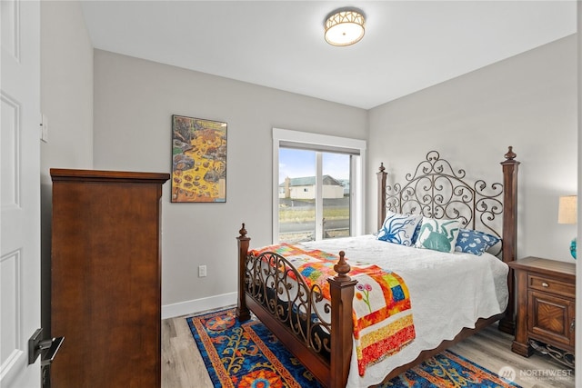 bedroom with baseboards and wood finished floors