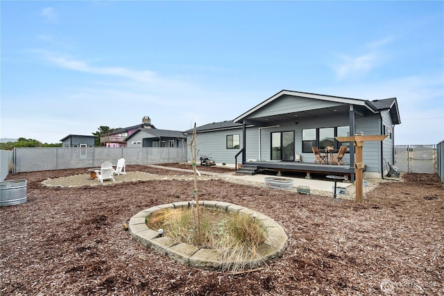 rear view of property featuring a deck and a fenced backyard