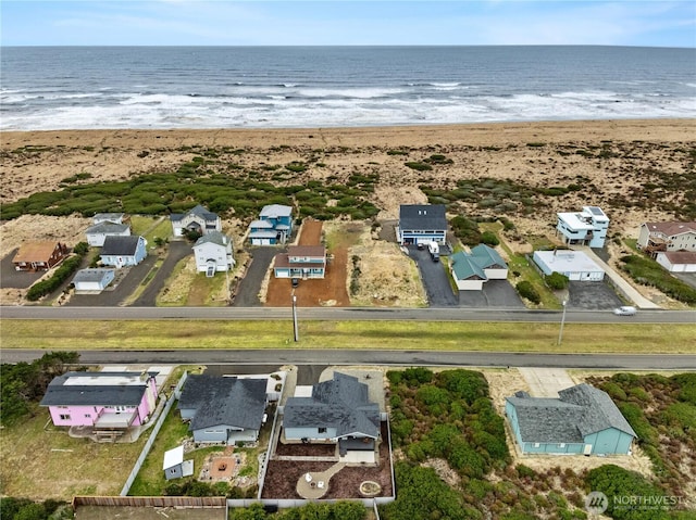 drone / aerial view featuring a beach view and a water view