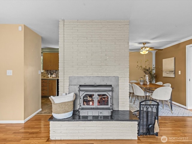 living room featuring wood finished floors, baseboards, and ceiling fan