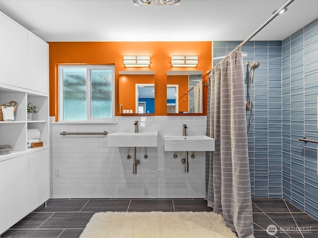 full bath featuring a sink, tile walls, and a tile shower