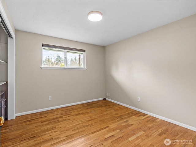 unfurnished bedroom with light wood finished floors, baseboards, and a closet