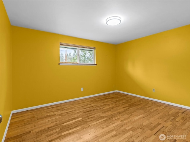 unfurnished room with baseboards and light wood-style floors