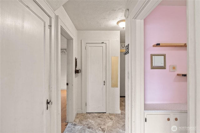 corridor featuring a textured ceiling