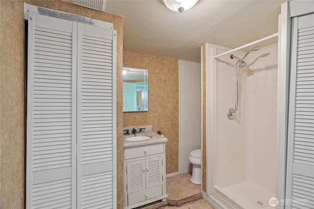 full bathroom with tile patterned floors, a closet, toilet, and a shower stall