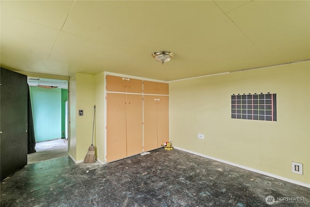 unfurnished bedroom featuring a closet, tile patterned floors, and baseboards