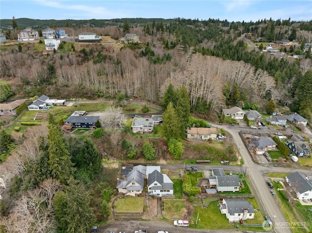 drone / aerial view featuring a forest view and a residential view