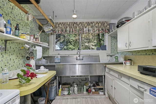 kitchen featuring tasteful backsplash, light countertops, ornamental molding, white cabinetry, and open shelves