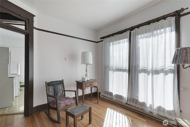 sitting room featuring baseboards and wood finished floors