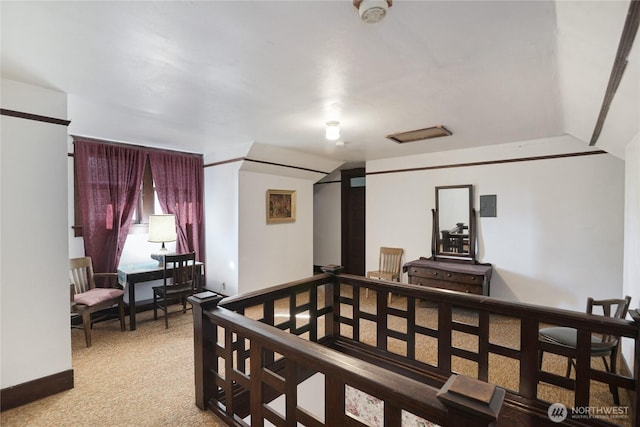 corridor with light carpet, lofted ceiling, and an upstairs landing