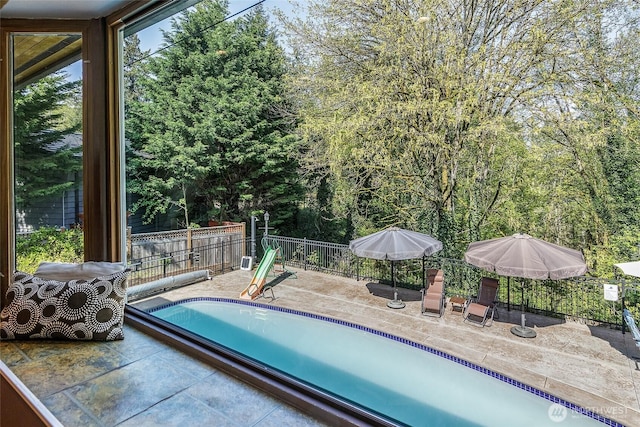 view of swimming pool with a patio, a fenced in pool, and fence