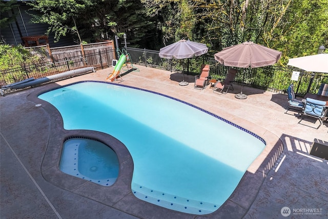 view of swimming pool with a patio, a fenced in pool, an in ground hot tub, and fence