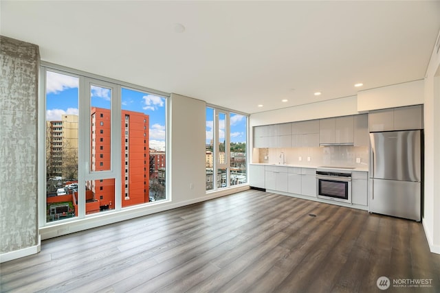 kitchen with a sink, gray cabinetry, light countertops, stainless steel appliances, and modern cabinets