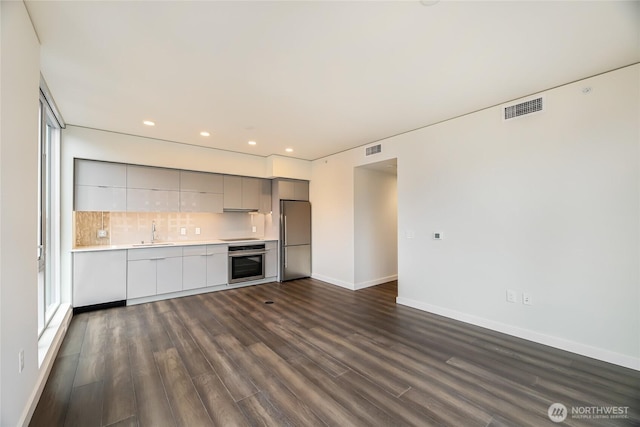 kitchen with visible vents, modern cabinets, a sink, appliances with stainless steel finishes, and light countertops