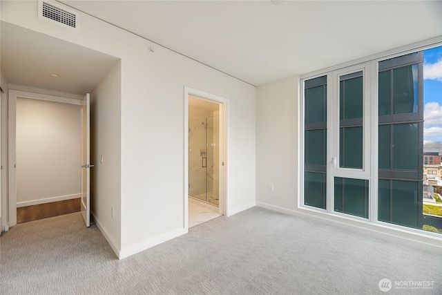 unfurnished bedroom with visible vents, baseboards, ensuite bath, and carpet flooring