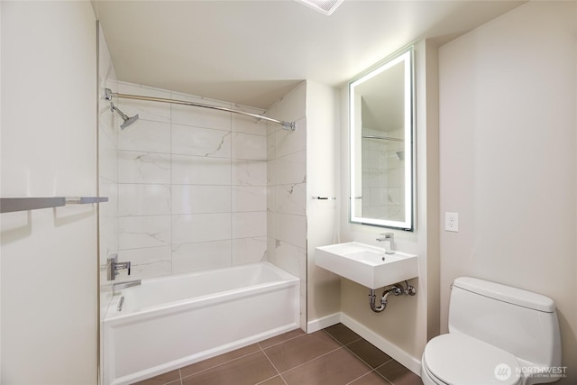 bathroom featuring baseboards, a sink, tile patterned flooring, shower / bathing tub combination, and toilet