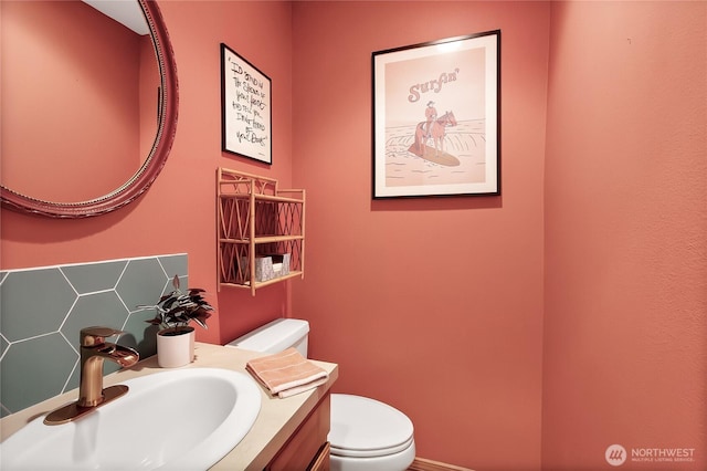 bathroom with backsplash, toilet, and vanity