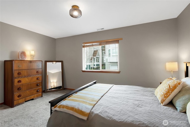 bedroom featuring visible vents and light colored carpet