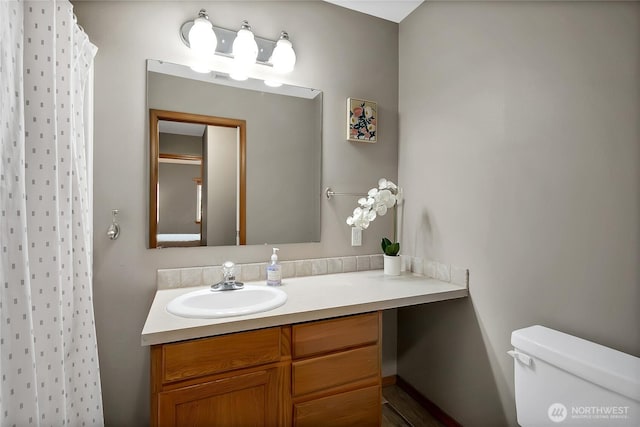 bathroom with a shower with curtain, toilet, and vanity