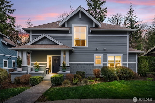 view of front of house featuring roof with shingles and covered porch