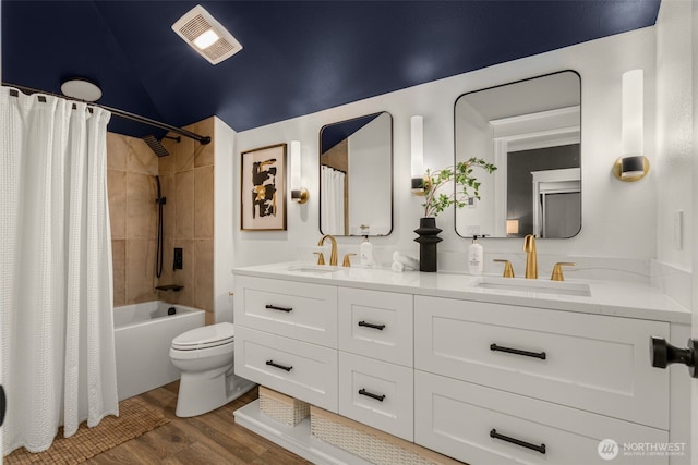 full bathroom featuring toilet, wood finished floors, visible vents, and a sink