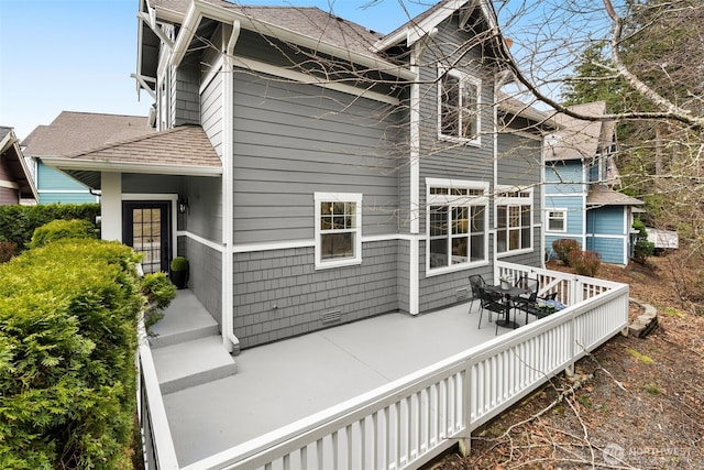 rear view of house with crawl space, roof with shingles, and a patio area