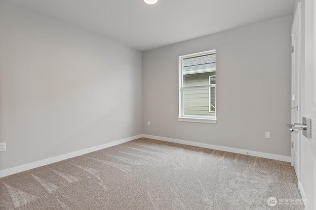 empty room featuring baseboards and carpet floors