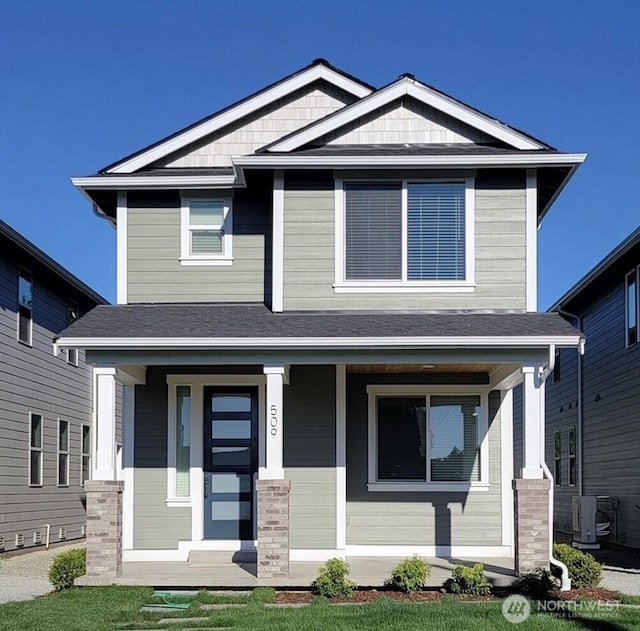 craftsman-style house with central air condition unit, covered porch, and a shingled roof