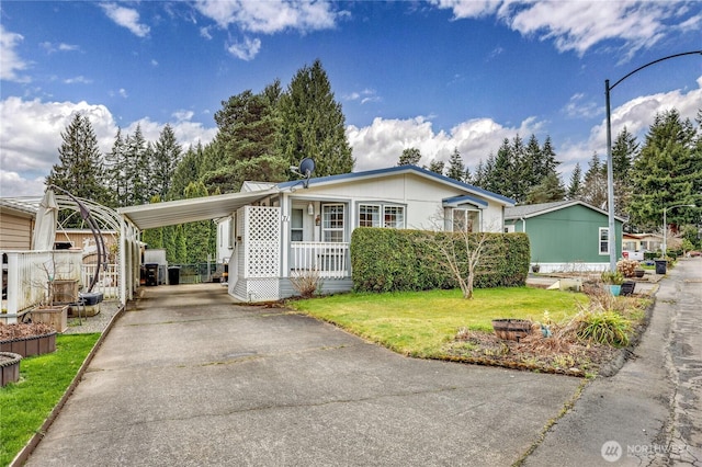 view of front of house with an attached carport, concrete driveway, a porch, and a front lawn