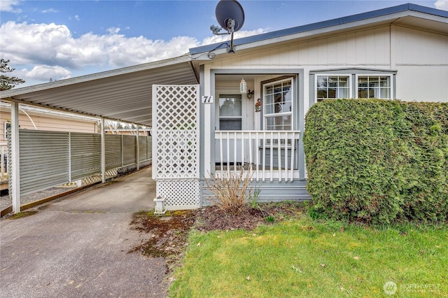 view of front of property featuring a carport, a porch, and driveway