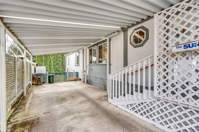 view of patio featuring an attached carport and fence