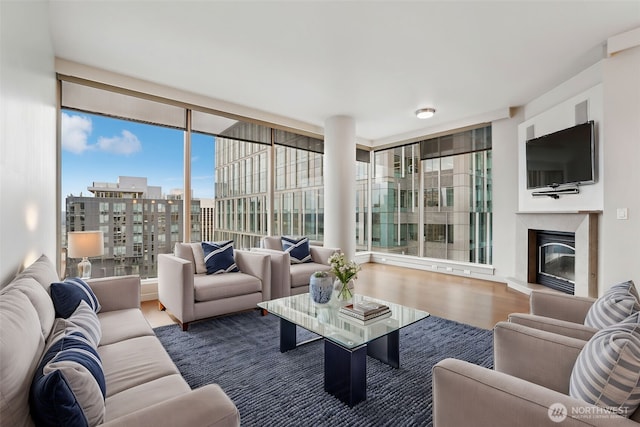10650 NE 9th Pl Unit 2220, Bellevue, WA 98004 - living area featuring a glass covered fireplace, a view of city, floor to ceiling windows, and wood finished floors