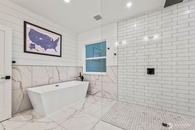 full bath featuring recessed lighting, a soaking tub, marble finish floor, and tiled shower