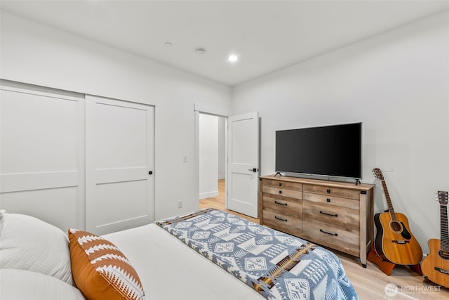 bedroom with recessed lighting, a closet, and light wood-style flooring