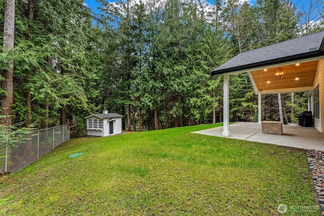 view of yard with a patio, an outdoor structure, and fence