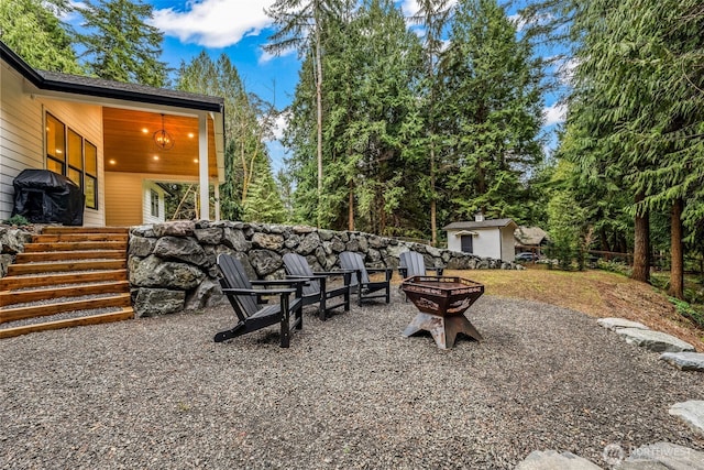 view of yard with a patio area, an outbuilding, and an outdoor fire pit