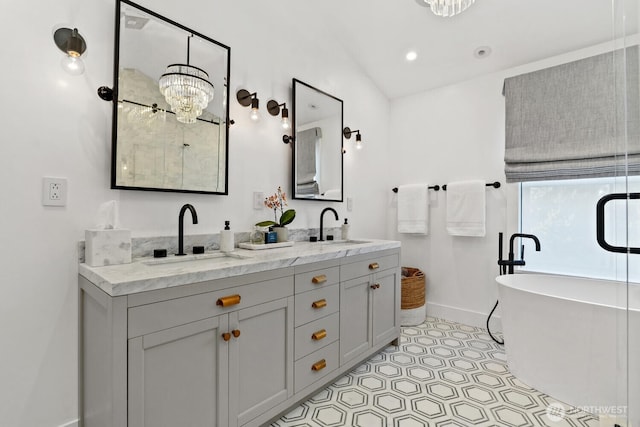 bathroom with double vanity, a soaking tub, lofted ceiling, and a sink