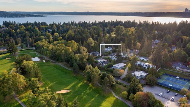 birds eye view of property featuring a water view and a wooded view