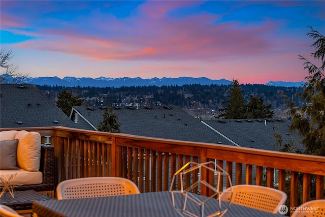 deck at dusk featuring a mountain view