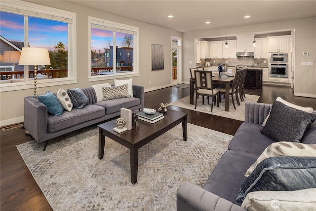 living room with recessed lighting, visible vents, and dark wood finished floors