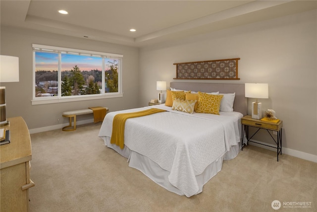 carpeted bedroom with recessed lighting, a tray ceiling, and baseboards