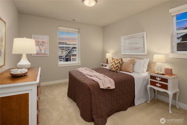 bedroom with light carpet, visible vents, and baseboards