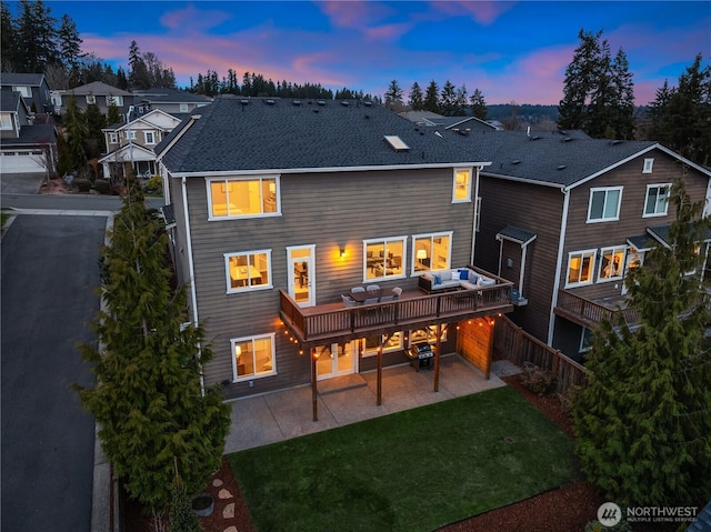 back of house featuring a patio, a lawn, fence, and a shingled roof