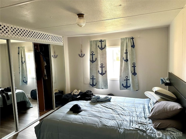 bedroom featuring a closet, a textured ceiling, and wood finished floors