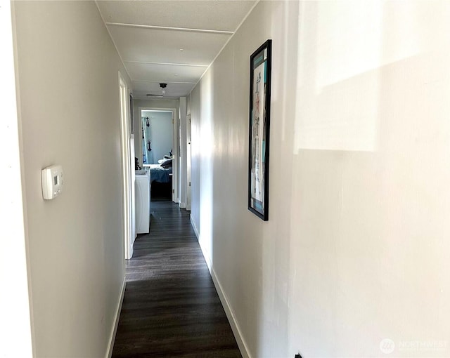 corridor with baseboards and dark wood-type flooring